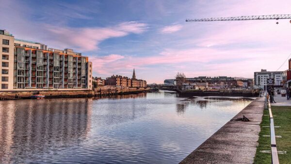 A wide angle, serene photograph of Grand Canal Dock in Dublin showing the dock and the sky above it - Chauffeur Driving Tours of Ireland