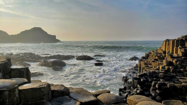 Giant's Causeway Private Driver Tour - The Giant's Causeway looking out towards a choppy sea with a spectacular headland in the distance