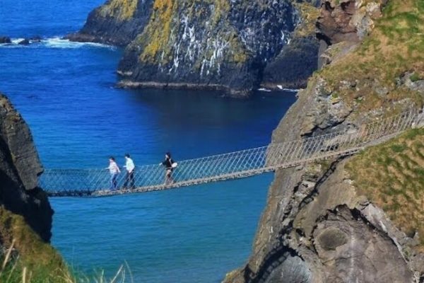 A photo of people crossing the famous Rope Bridge at Carrick-a-Rede near the Giant's Causeway in our private chauffeur tour itinerary.